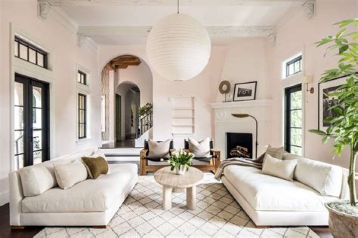 a living room with two couches and a table in front of a fire place